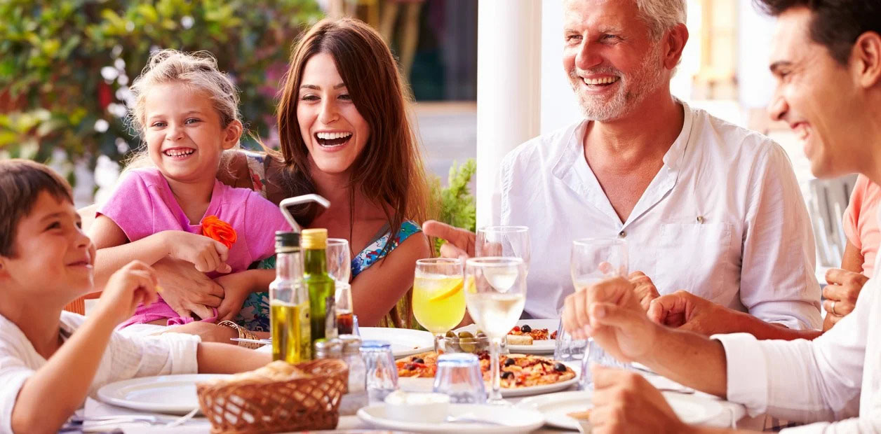 Familia joven reunida en la mesa durante un almuerzo